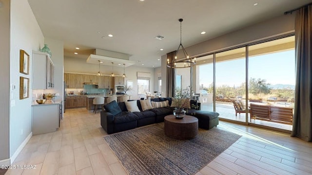 living area featuring a notable chandelier, recessed lighting, light wood-style flooring, and visible vents