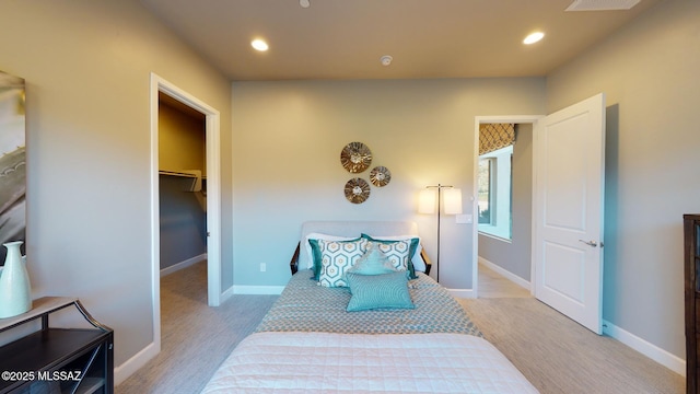 bedroom featuring a spacious closet, recessed lighting, and baseboards