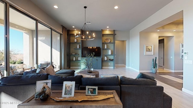 living room featuring visible vents, a notable chandelier, light wood-style flooring, recessed lighting, and baseboards