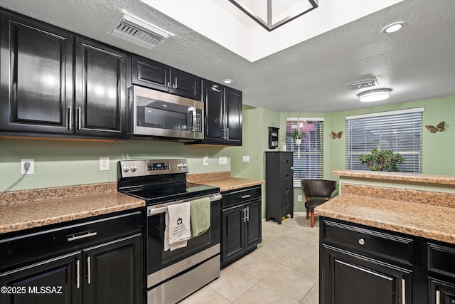 kitchen with appliances with stainless steel finishes and dark cabinetry