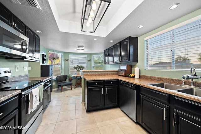 kitchen with visible vents, stainless steel appliances, dark cabinetry, and a sink