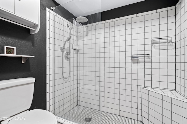 bathroom with tiled shower and toilet