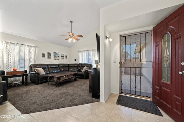 entrance foyer with light tile patterned floors, light colored carpet, a ceiling fan, and vaulted ceiling