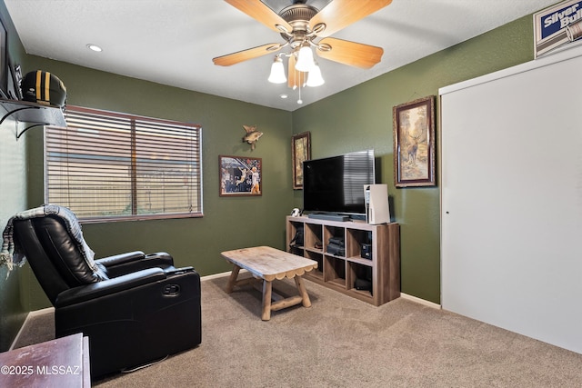 living area featuring carpet floors and ceiling fan