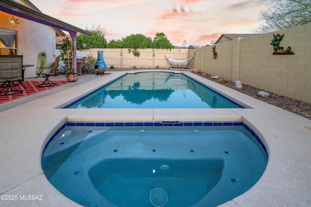 view of swimming pool featuring a fenced in pool, an in ground hot tub, and a fenced backyard