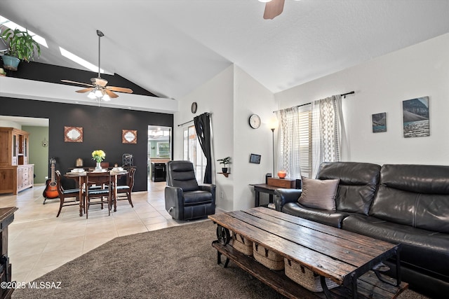 living area with high vaulted ceiling, light tile patterned flooring, and a ceiling fan