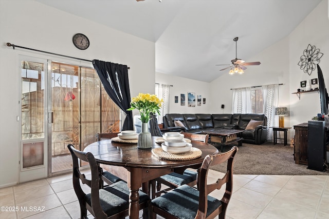 dining area with light tile patterned flooring, light carpet, high vaulted ceiling, and a ceiling fan