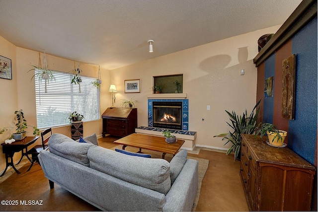 living room with vaulted ceiling, a fireplace, baseboards, and a textured ceiling