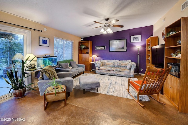 living area with visible vents, a textured ceiling, and ceiling fan