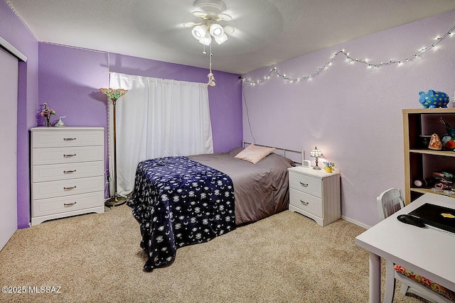 bedroom with light carpet, a textured ceiling, and ceiling fan