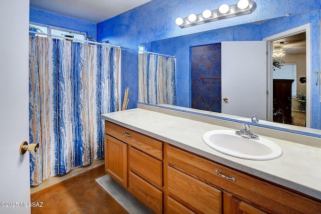 bathroom featuring vanity and a textured wall