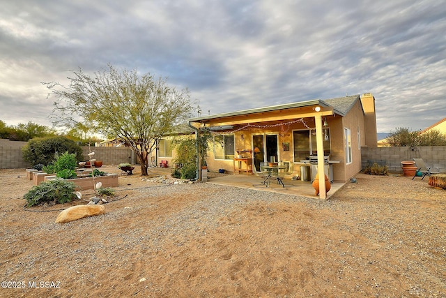 back of house featuring a patio, a fenced backyard, and stucco siding