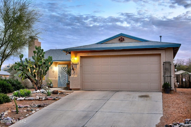 single story home with stucco siding, concrete driveway, and an attached garage