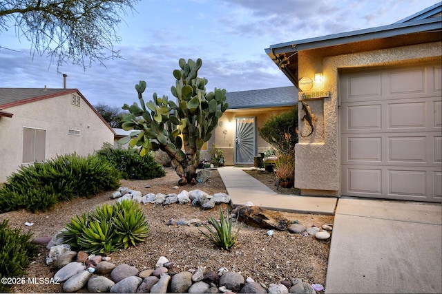 exterior space with a garage and stucco siding