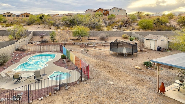 view of pool featuring an outbuilding, a patio, a trampoline, a fenced backyard, and a fenced in pool