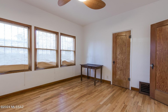 empty room featuring visible vents, baseboards, light wood-style floors, and ceiling fan