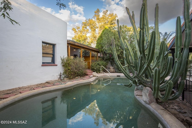 pool with a patio area and fence