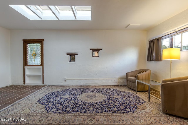 living area with brick floor, a skylight, and a textured wall