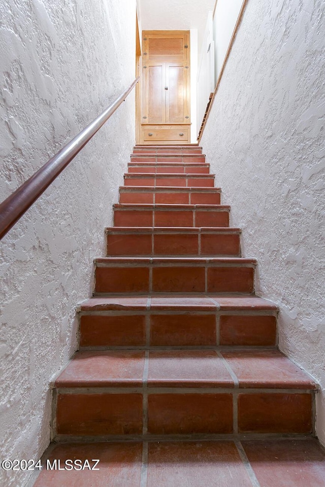 staircase with a textured wall