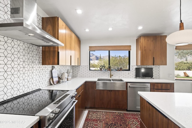 kitchen with dishwasher, light countertops, electric range oven, wall chimney exhaust hood, and a sink