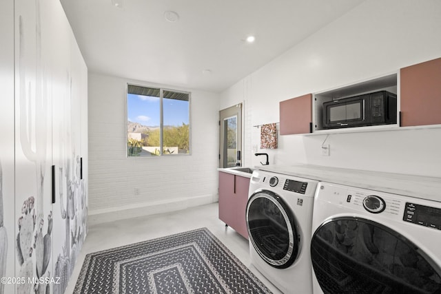 clothes washing area with washer and dryer, laundry area, recessed lighting, and a sink