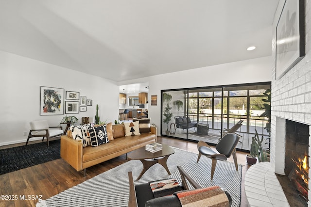 living area with a brick fireplace, wood finished floors, and baseboards