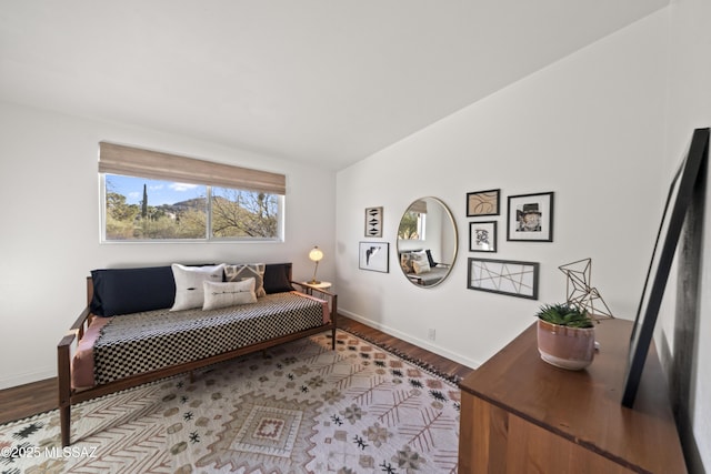 living area featuring baseboards, lofted ceiling, and wood finished floors