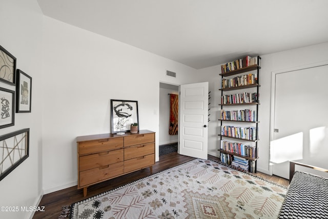 bedroom featuring visible vents, baseboards, and dark wood-style flooring