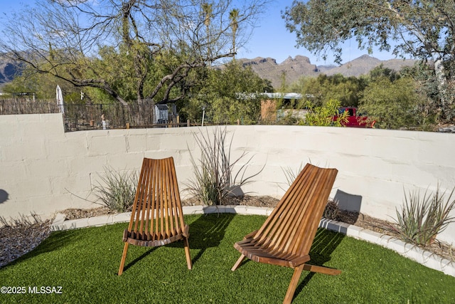 view of yard featuring a mountain view and fence