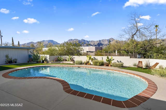 view of swimming pool featuring a patio area, a fenced in pool, a fenced backyard, and a mountain view