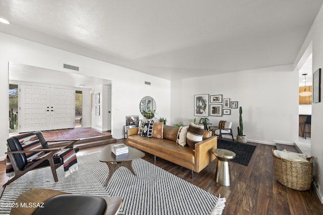 living room featuring wood finished floors, visible vents, and baseboards