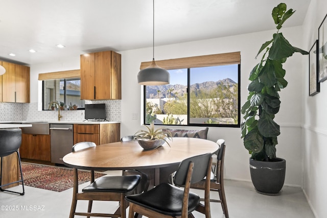 dining space with a wealth of natural light, baseboards, concrete flooring, and recessed lighting