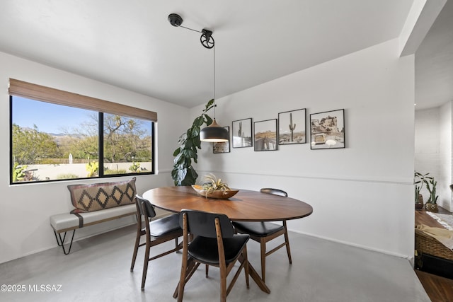 dining area featuring concrete flooring and baseboards