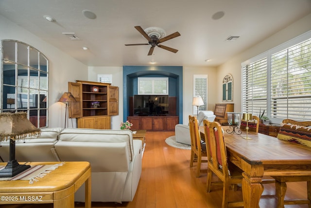 living room featuring hardwood / wood-style flooring, a ceiling fan, and visible vents