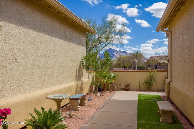 view of yard with a patio area, fence, and a mountain view