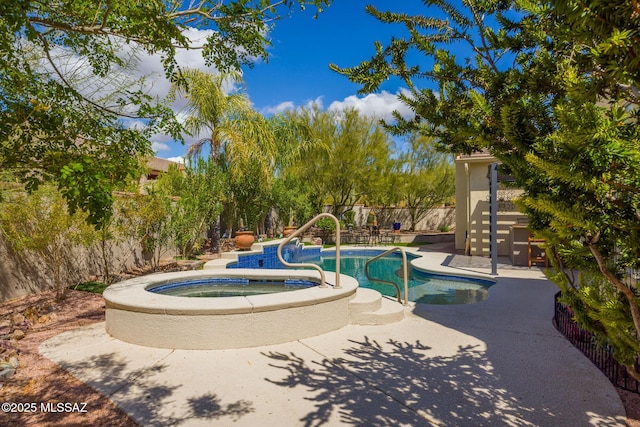 view of swimming pool featuring a pool with connected hot tub, a fenced backyard, and a patio area