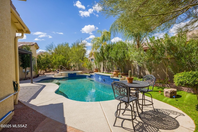 view of pool featuring a patio, a fenced backyard, and a pool with connected hot tub