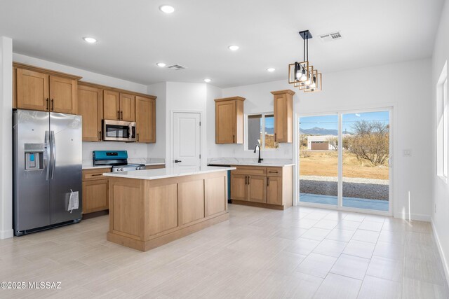 kitchen featuring a kitchen island, light countertops, recessed lighting, appliances with stainless steel finishes, and a sink