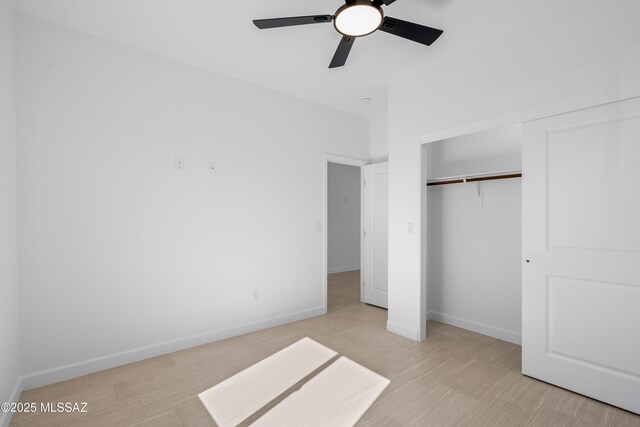 unfurnished bedroom featuring a closet, baseboards, light wood-style flooring, and a ceiling fan