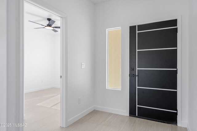 interior space featuring baseboards and a ceiling fan