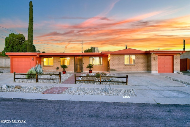 915 N Bedford Dr, Tucson, AZ 85710 - view of front of property featuring brick siding, driveway, fence, and a garage