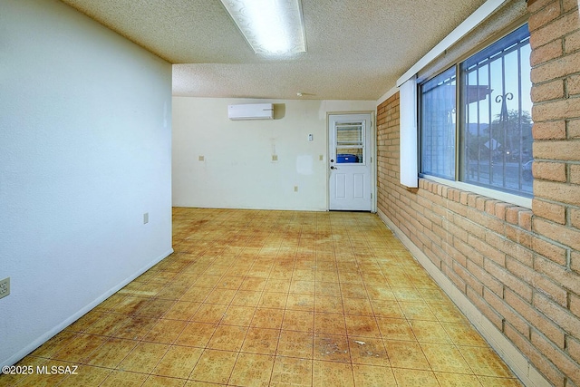 unfurnished room featuring light floors, a wall mounted AC, and a textured ceiling