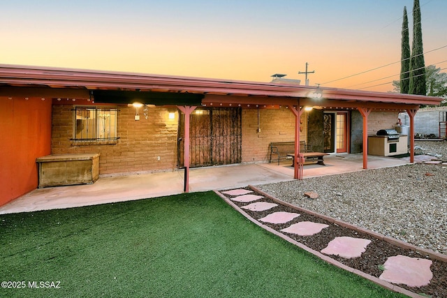 rear view of property featuring brick siding and a patio area