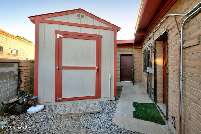 view of shed featuring fence