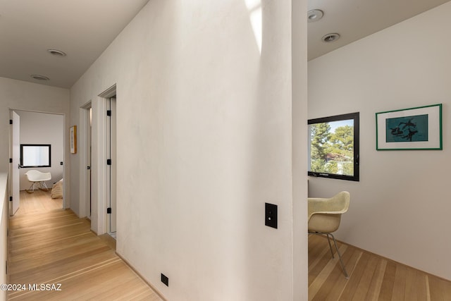 hallway with a wealth of natural light and light wood-style flooring