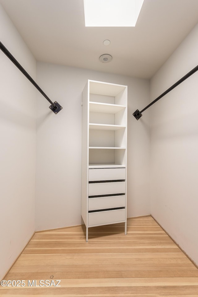 walk in closet with wood finished floors