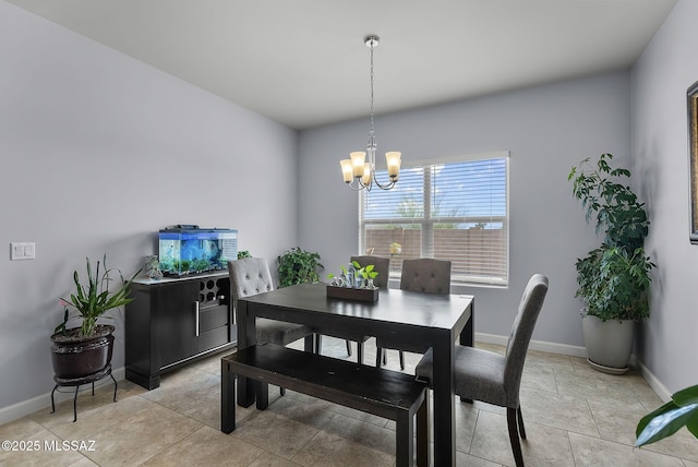 dining space with baseboards and a chandelier