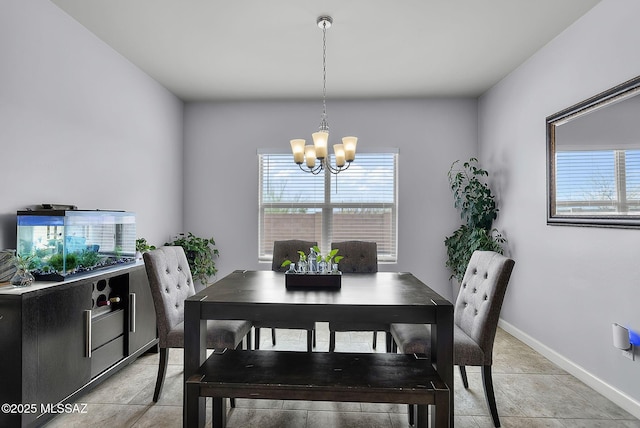 dining area with light tile patterned floors, baseboards, and a chandelier