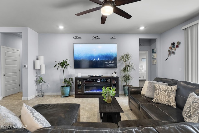 living room with a glass covered fireplace, recessed lighting, a ceiling fan, and baseboards