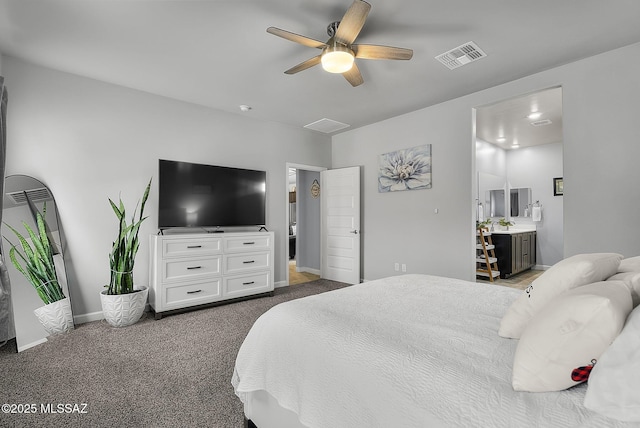 carpeted bedroom with ensuite bath, visible vents, a ceiling fan, and baseboards